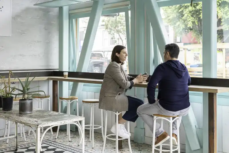 two people sitting in a bar and talking